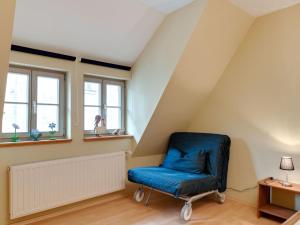 a room with a blue chair in a attic at Attractive Apartment in Quedlinburg in Quedlinburg