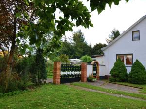 una cerca en el patio de una casa blanca en Spacious Holiday Home in Sommerfeld near Lake, en Kremmen