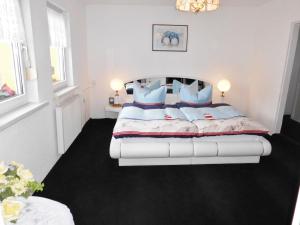 1 dormitorio con 1 cama blanca grande con almohadas azules en Spacious Holiday Home in Sommerfeld near Lake, en Kremmen