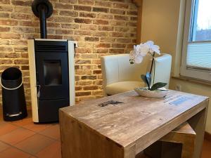 a wooden table with a vase of white flowers on it at Detached holiday home in the Harz with wood stove and covered terrace in Güntersberge