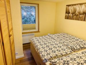 a small bedroom with a bed and a window at Detached holiday home in the Harz with wood stove and covered terrace in Güntersberge