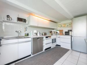una cocina con armarios blancos y electrodomésticos blancos en Spacious apartment near the Teutoburg Forest, en Leopoldshöhe