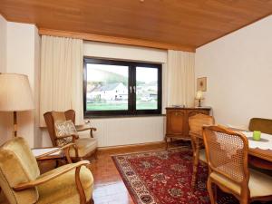 a living room with a table and chairs and a window at Cozy Holiday Home in Wallenborn with Garden in Wallenborn