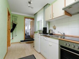 a kitchen with white appliances and green walls at Elite holiday home with garden in Spreenhage in Grünheide