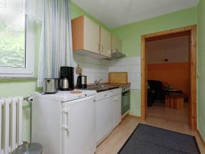 a small kitchen with a refrigerator and a sink at Elite holiday home with garden in Spreenhage in Grünheide