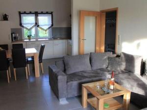 ein Wohnzimmer mit einem Sofa und einem Tisch in der Unterkunft Cozy Holiday Home in Willersdorf with Pond in Frankenberg