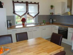 a kitchen with a wooden table and a table and chairs at Cozy Holiday Home in Willersdorf with Pond in Frankenberg