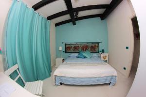 a bedroom with a large bed with blue curtains at B&B I Fiori del Mare in Agropoli