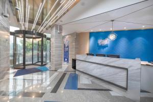 a lobby with a reception desk and a blue wall at Holiday Inn Express Shanghai Gubei, an IHG Hotel in Shanghai