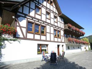 ein Gebäude mit Stühlen und Blumen davor in der Unterkunft Apartment in Oberkirchen near Winterberg Skiing in Schmallenberg