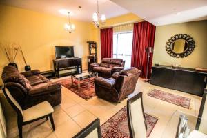 a living room with couches chairs and a television at 2 Bedroom Apartment - JBR in Dubai