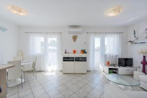 a white living room with a kitchen and a table at Holiday house in rural Istria with pool and hydromassage in Žminj