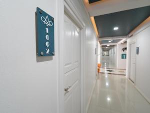 um corredor hospitalar com um sinal na porta em RoomQuest Rojana Industrial Estate area em Ban Nong Phai