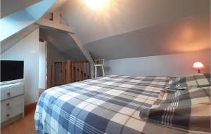 a bedroom with a blue and white bed and a tv at Cozy Home In Ambleteuse With Wifi in Ambleteuse