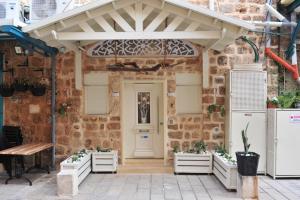 a brick building with a white door and awning at Akka in Acre