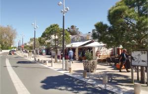 a street with people walking down the street at Three-Bedroom Holiday Home In La Tranche Sur Mer in La Tranche-sur-Mer