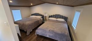 duas camas num quarto com duas janelas em MANITOU BEACH COTTAGES by Prowess em Manitou Beach