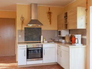 a kitchen with white cabinets and an oven at Charming Holiday Home in Hohnstein ot Lohsdorf in Hohnstein
