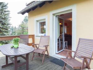 a patio with a table and chairs on a deck at Charming Holiday Home in Hohnstein ot Lohsdorf in Hohnstein