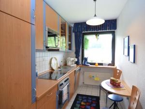 eine kleine Küche mit einem Waschbecken und einem Tisch in der Unterkunft Cosy apartment over Usseln with private terrace in Willingen