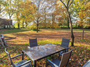 a table and chairs with leaves on the ground at Historic half timbered Farm in Hohnebostel near Watersports in Langlingen