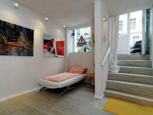 a living room with a chair and stairs with paintings at Apartment in Kreuzberg with internet in Berlin