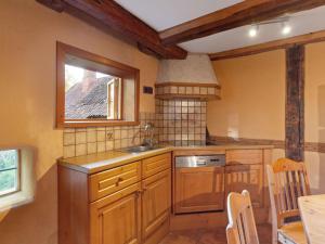 a kitchen with wooden cabinets and a window and a sink at Historic half timbered Farm in Hohnebostel near Watersports in Langlingen