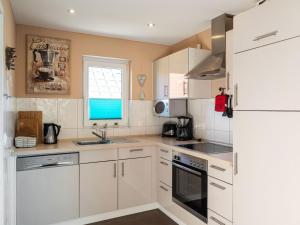 a kitchen with white cabinets and a window at Holiday home in Hasselfelde with garden in Hasselfelde