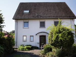 a white house with a black roof at Apartment with sauna in Merlsheim