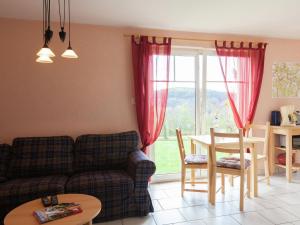 ein Wohnzimmer mit einem Sofa, einem Tisch und einem Fenster in der Unterkunft Chic Vacation Home near Forest in Sebnitz Germany in Mittelndorf