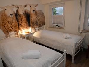 a room with two beds with sheep heads on the wall at Apartment with sauna in Merlsheim