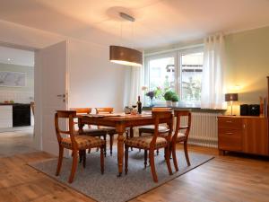 a kitchen and dining room with a wooden table and chairs at Apartment with sauna in Merlsheim