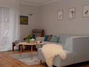 a living room with a couch and a table at Apartment with sauna in Merlsheim