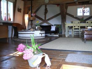 ein Wohnzimmer mit Sofa und Blumen auf dem Boden in der Unterkunft Beautiful authentic mill close to the beach in Wangels