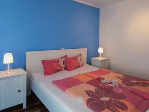 a bedroom with a bed with red pillows and blue walls at Gemütliches Ferienhaus in Sebnitz in Mittelndorf +32 photos