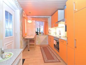 małą kuchnię z pomarańczowymi szafkami i stołem w obiekcie Vintage Holiday Home in Trieb with Terrace w mieście Trieb