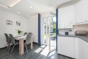 a kitchen and dining room with a table and chairs at Domy Rafa Ustka in Ustka