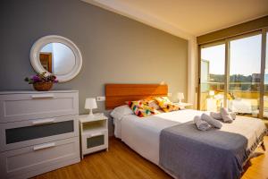 ファロ・デ・クリェラにあるCap Blanc Penthouse Culleraのベッドルーム(大型ベッド1台、鏡付)