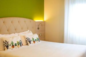 Hotel Castello Artemide Congressi في كاستيل سان بييترو تيرمي: غرفة نوم بسرير ابيض بجدار اخضر