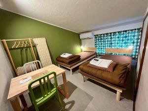 郡上市にあるunattended check-in accommodation in Gujo Hachimanのベッド2台とテーブルが備わる小さな客室です。