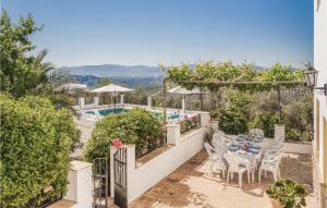 a patio with a table and chairs and a pool at Awesome Home In Iznjar With House A Mountain View in Villanueva de Tapia