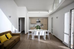 ein Wohnzimmer mit einem weißen Tisch und einem Sofa in der Unterkunft Case Vacanza Viola di Mare in Custonaci