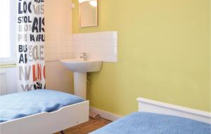アロマンシュ・レ・バンにあるNice Home In Arromanches-les-bains With 2 Bedroomsの小さなバスルーム(シンク、ベッド付)