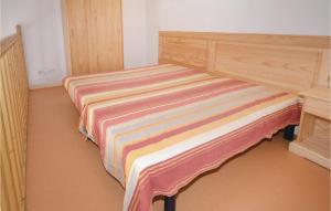 a bed with a striped blanket on it in a room at Cozy Home In Calvisson With Kitchen in Calvisson +38 photos