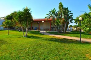 a house with palm trees in front of a yard at Ariadni Apartments in Karteros
