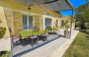 a patio with a green table and chairs at La Bastide in Grignan