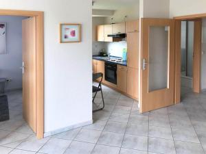 ヴィリンゲンにあるApartment in Willingen with terraceのキッチン(木製キャビネット、テーブル、椅子付)