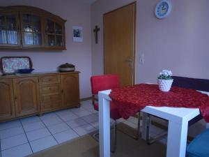 una cucina con tavolo e tovaglia rossa di Mountain view Apartment in Mullenborn Garden a Gerolstein