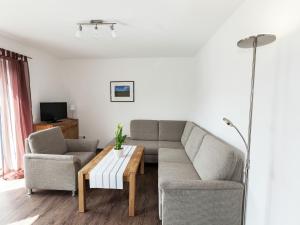 ein Wohnzimmer mit einem Sofa und einem Couchtisch in der Unterkunft Holiday home with terrace near volcanic lakes in Ellscheid