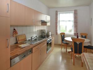 a kitchen with a sink and a table with a dining room at Lovely Farmhouse in Friedrichsfeld with Garden in Trendelburg